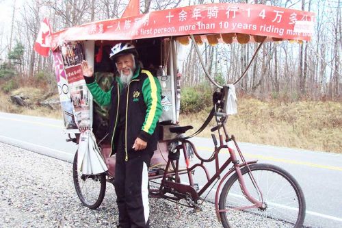 Chen Guan Mingand his long distance rickshaw on highway 7 near Sharbot Lake.